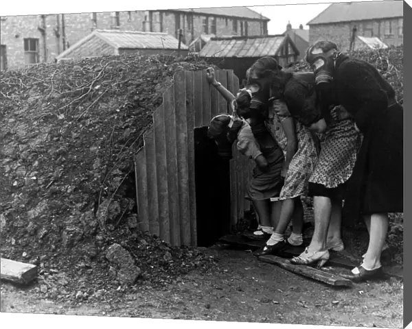 A family wearing gas masks go into an Anderson air raid shelter