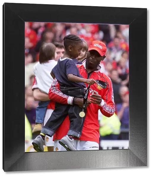Andy Cole Manchester United footballer May 1999 celebrating carrying his young son