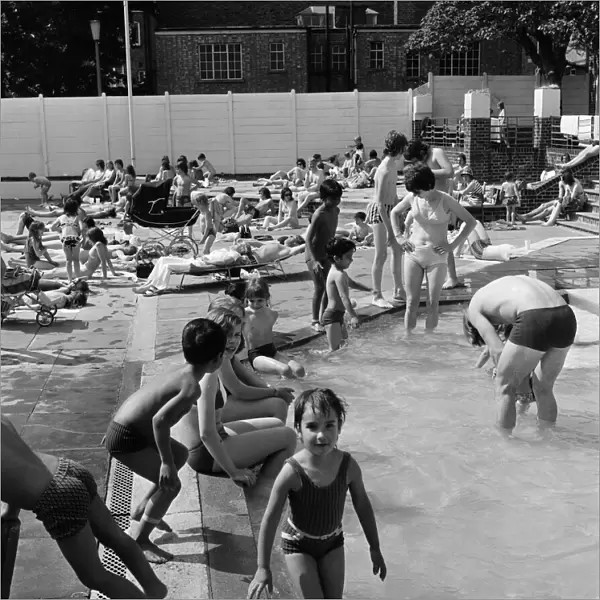 Crowds of sunbathers at the Twickenham outdoor swimming pool. 7th June 1975
