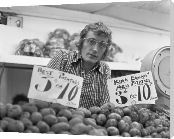 Greengrocer and his fruit and veg stall in Staffords indoor market. Circa June 1974