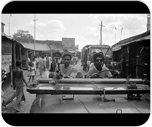 India - War Scenes - 1971 men driving through a street armed with guns