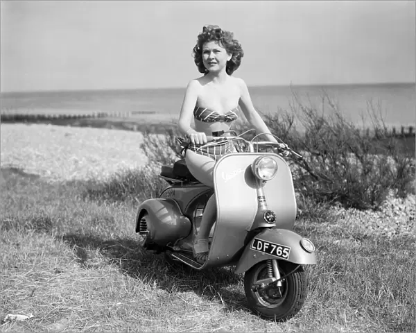 A girl on a Vespa motor scooter. 1952