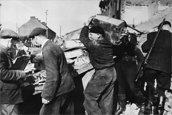 Free French Infantry carry off arms and ammunition from a knocked out German truck
