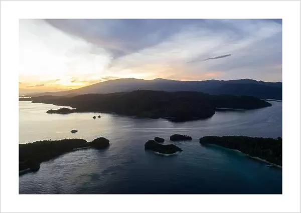 A peaceful sunrise illuminates the remote, tropical islands scattered through Raja Ampat, Indonesia. This area is known for its high biodiversity