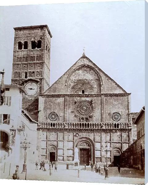 Facade and bell tower of the Cathedral of Assisi dedicated to San Rufino. In the foreground, the square with adults and children