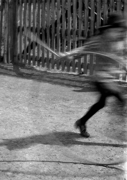 Blurred image of child with hoop and stick