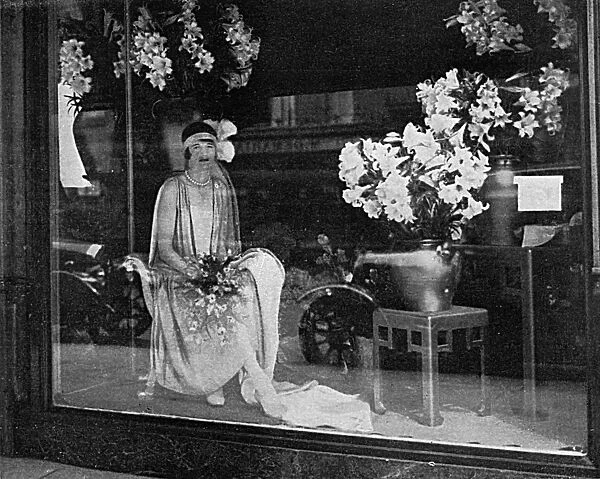 Debutante poses in a shop window, 1928