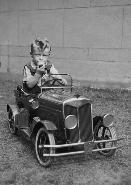 Little boy sitting in a toy car