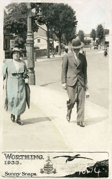 Mother and adult son stroll along a Worthing pavement
