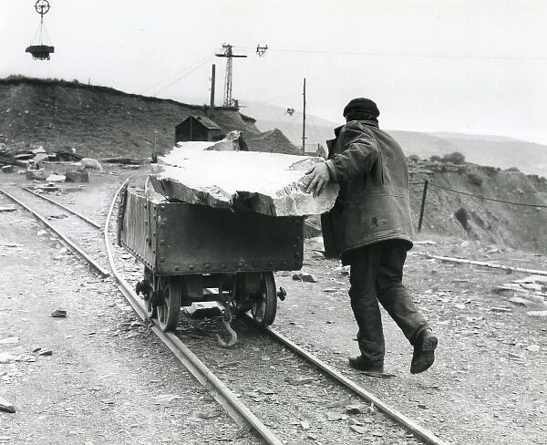 Workman pushing slate quarry tram, North Wales
