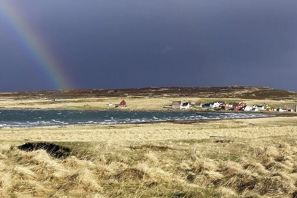 Village d'Ekkoroy by Varanger fjord with storm clouds and rainbow - Norway