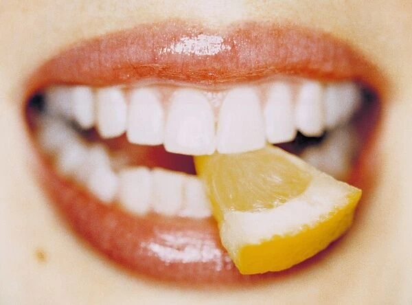 Slice of lemon between teeth