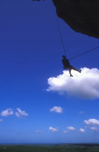 Abseiling above the jungle from the overhanging cliffs of La Costanera