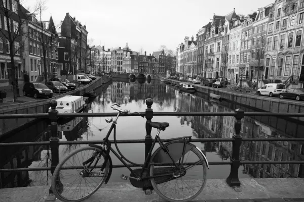 Black and white imge of an old bicycle by the Singel canal, Amsterdam, Netherlands