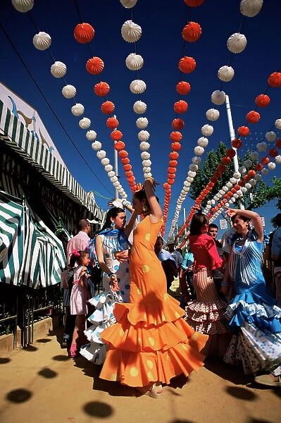 Girls dancing a sevillana beneath colourful lanterns