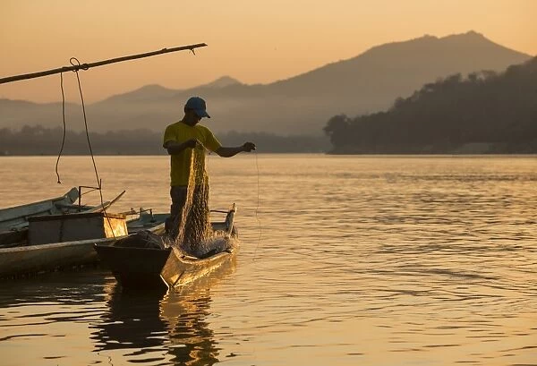 Man reeling in fishing net on Mekong River, Luang Prabang, Laos, Indochina, Southeast Asia, Asia