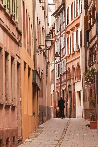 A man walks through La Petite France, Grande Ile, UNESCO World Heritage Site, Strasbourg, Bas-Rhin, Alsace, France, Europe