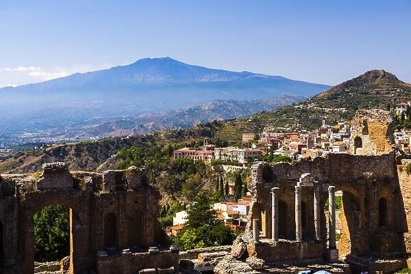 Mount Etna Volcano with ruins of Teatro Greco (Greek Theatre) in the foreground, Taormina, Sicily, Italy, Europe