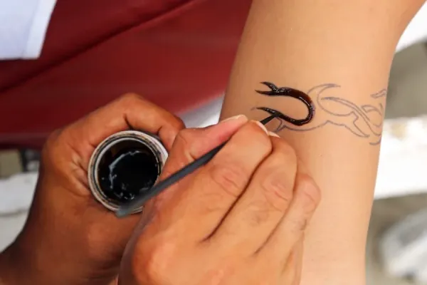 Tattoos for tourists. Temporary henna tattoo being applied, Legian Beach, Denpasar, Bali, Indonesia