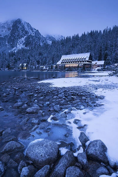 Frozen lake shore and Mountain House at twilight, Popradske Pleso, High Tatras, Slovakia