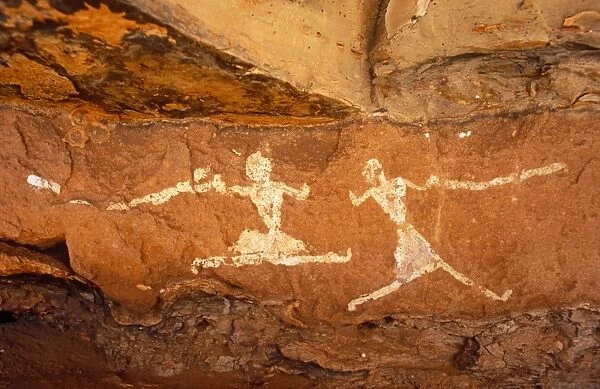 Libya, Fezzan, Jebel Akakus. A pair of running figures painted onto the walls of Uan Muhuggiag