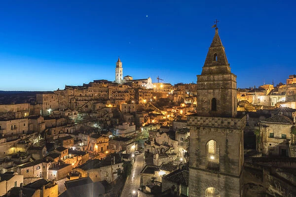 The Sassi quarter at dusk, with San Pietro Barisano bell tower in the foreground. Matera