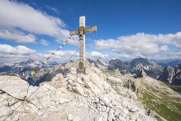 Wooden cross on top of Mount Paterno and surrounding landscape in summer. Sesto Dolomites