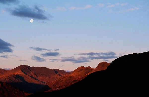 The moon over Bowfell and the Langdale Pikes in the Lake district UK