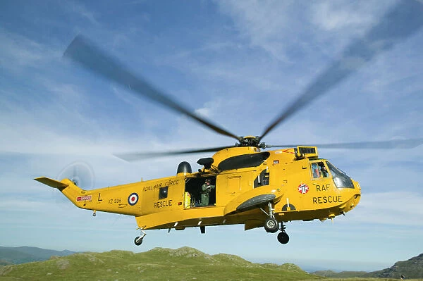 RAF Sea King Helicopter about to land on Crinkle Crags in the Lake district to evacuate an injured walker being treated by a mountain rescue team