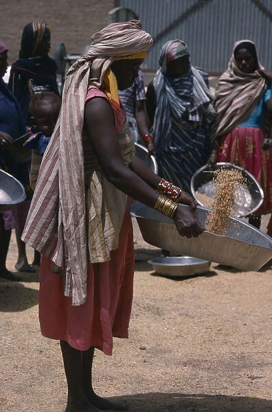 20075242. SUDAN Work Nigerian woman with child in sling on her back winnowing grain