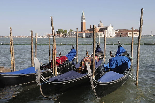 Italy, Veneto, Venice, gondolas along waterside at Il Molo with view across to San