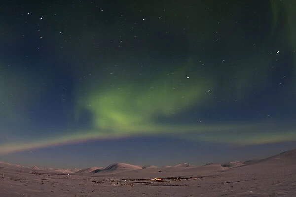 The aurora borealis is seen on Beam Road above snow-covered tundras near Nome, Alaska