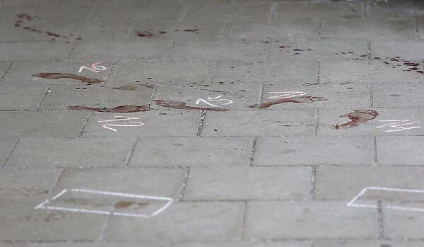 Bloodstained footprints and a trail of blood are seen on the floor of a train station