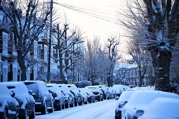 Cars are seen on a snow covered street in South London