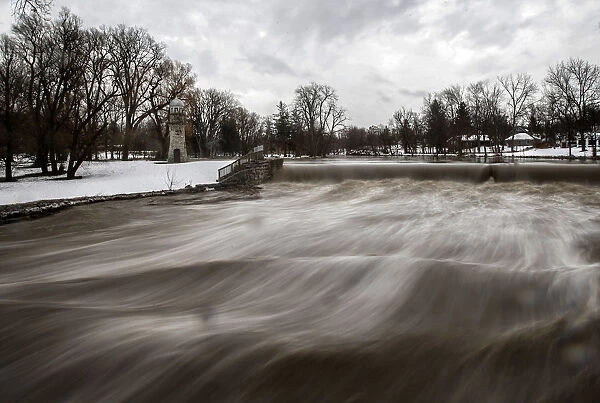 Cayuga Creek water rushes past a neighbourhood following a massive snow storm in