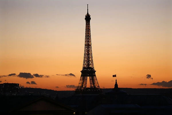 The Eiffel Tower is seen in silhouette at sunset in Paris