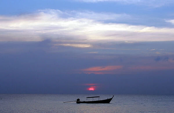 Fishing boat sits anchored in calm waters off coast in Thailands Phang Nga province