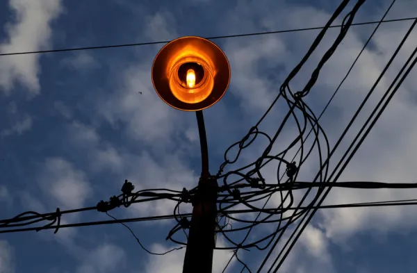 A lighting pole with electrical and telephone cables are seen in a street in Asuncion