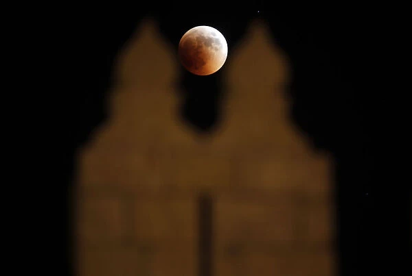 The moon is seen behind the wall of Damascus gate in Jerusalem Old City during a total