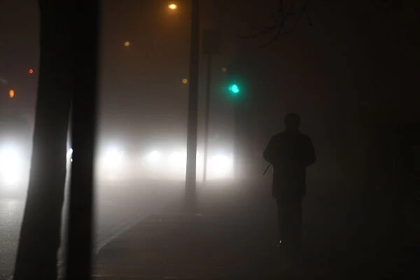 A person walks along a path during heavy fog in Dublin