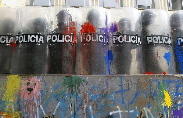 Riot policemen stand with their shields painted by students during a demonstration in
