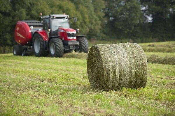 90325-00234-821. Round bale of silage in field, with tractor