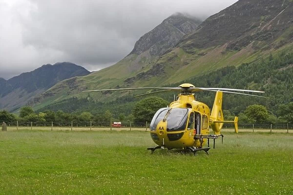 North West Air Ambulance, helicopter in upland valley pasture, Buttermere, Lake District, Cumbria, England, july