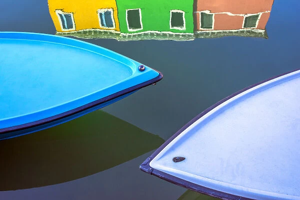 Italy, Burano. Boat bows and house reflection in canal