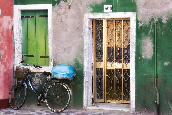 Italy, Venice. An old bicycle leans against a weathered house on the island of Burano