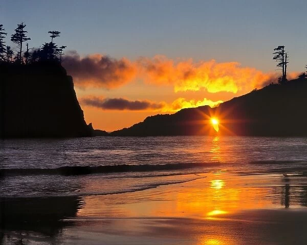 USA, Washington State, Olympic NP. The sun peeks through an arch at Second Beach in Olympic NP