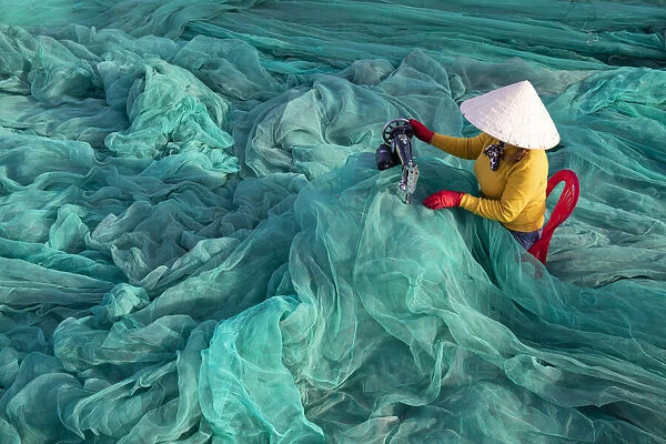 Vietnam. Fishing net analysis and repair with old fashioned