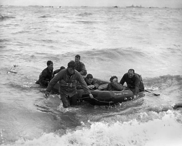 American survivors of a sunken LCVP landing craft come safely ashore during the D-Day invasion of Omaha Beach, Normandy, France, 6 June 1944