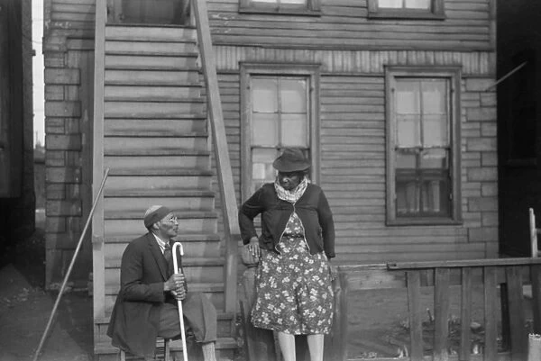 CHICAGO: CONVERSATION, 1941. Two African American woman talking outside of an apartment