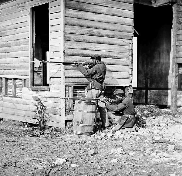 CIVIL WAR: UNION SOLDIERS. African American troops firing rifles at the picket station near Dutch Gap Canal in Dutch Cap, Virginia. Photograph, November 1864